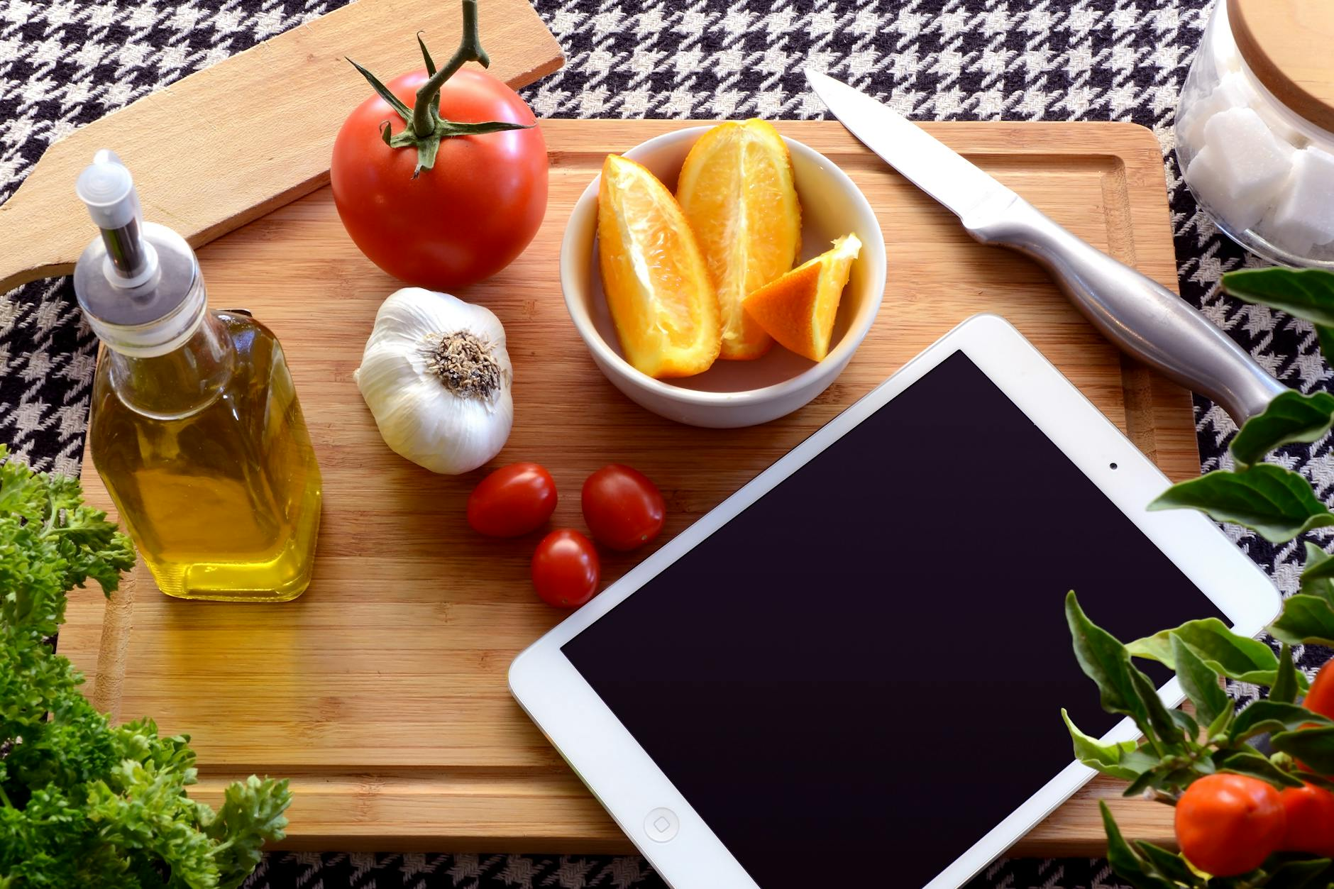 Person comparing nutrition tracking features on a tablet with healthy food preparation in background