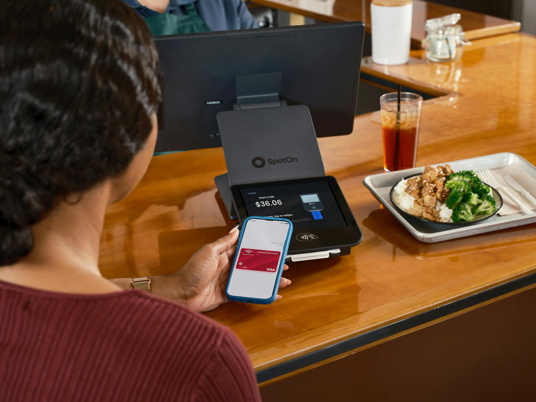 Smartphone displaying a calorie tracking app reading a Woolworths ready meal nutrition panel beside a chilled chicken and rice meal opened on a plate with a glass of water on a sunlit Australian kitchen counter