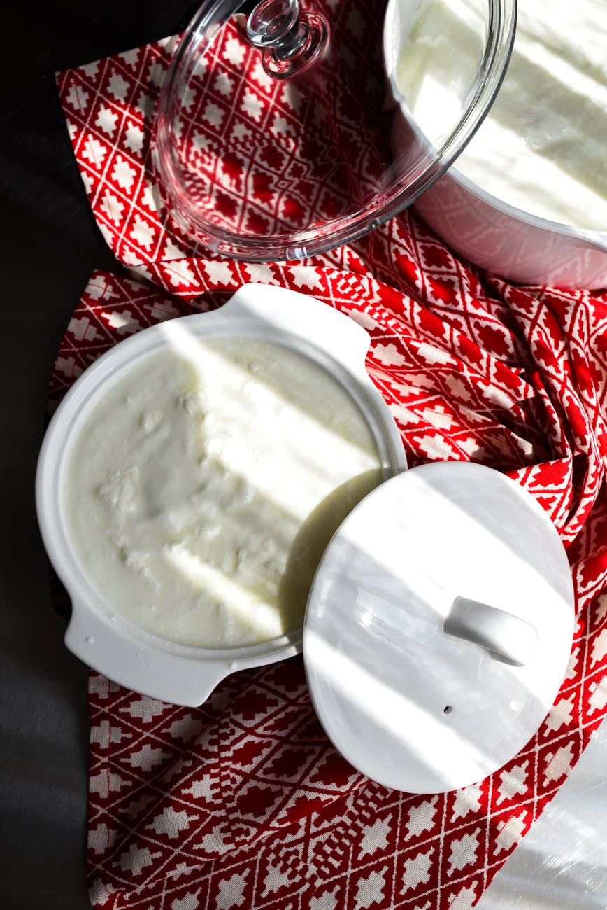 Bowls of plain yogurt, kefir, and fermented vegetables on a wooden kitchen counter showcasing live-culture probiotic foods that support gut health