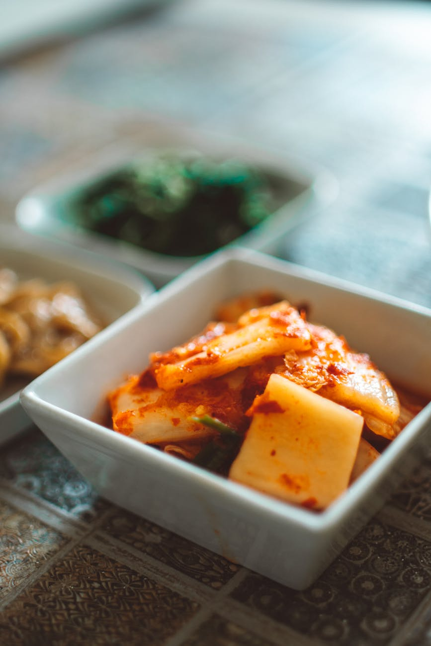 Fermented foods including kimchi, yogurt, kefir, sauerkraut, and miso arranged in ceramic bowls