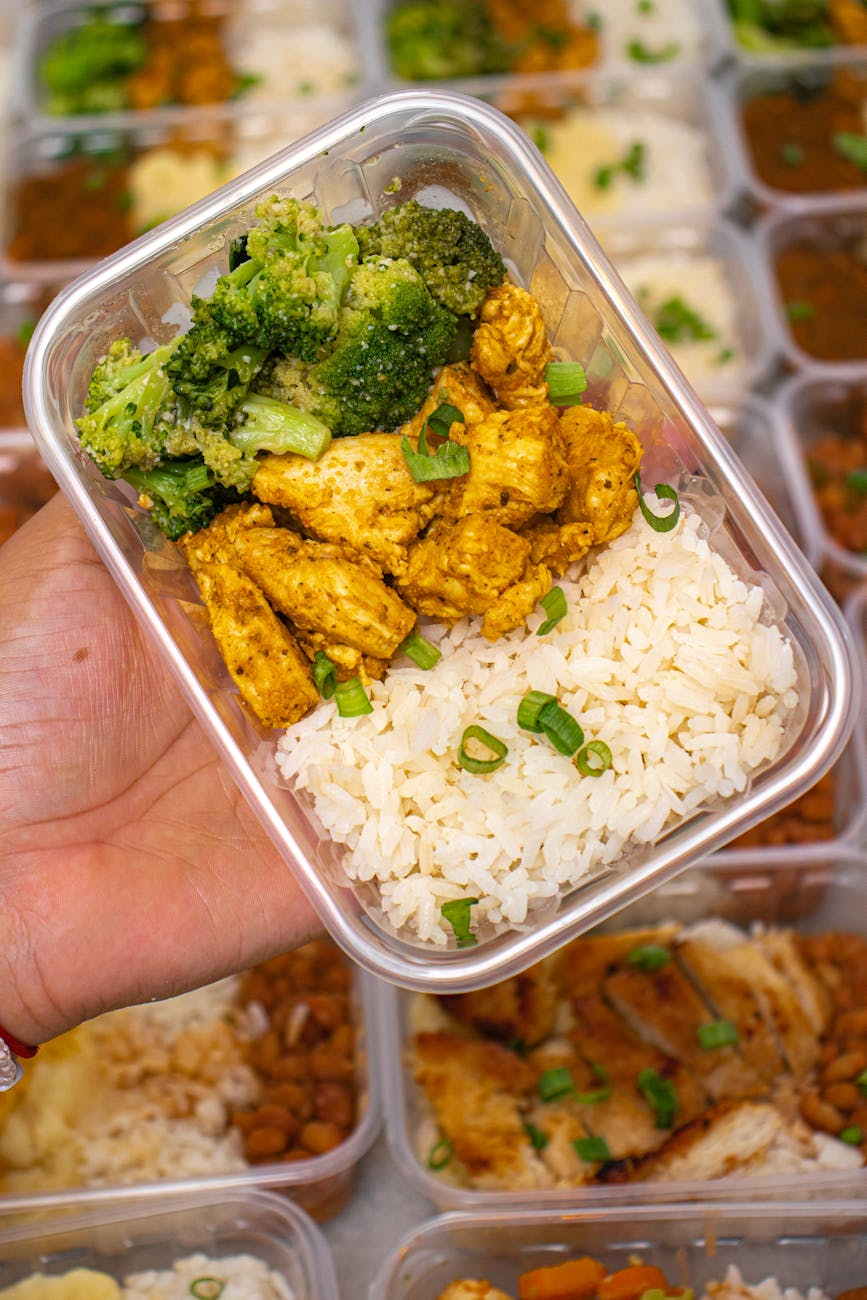 Close-up of a plated meal with chicken, rice, and broccoli being analyzed on a smartphone screen