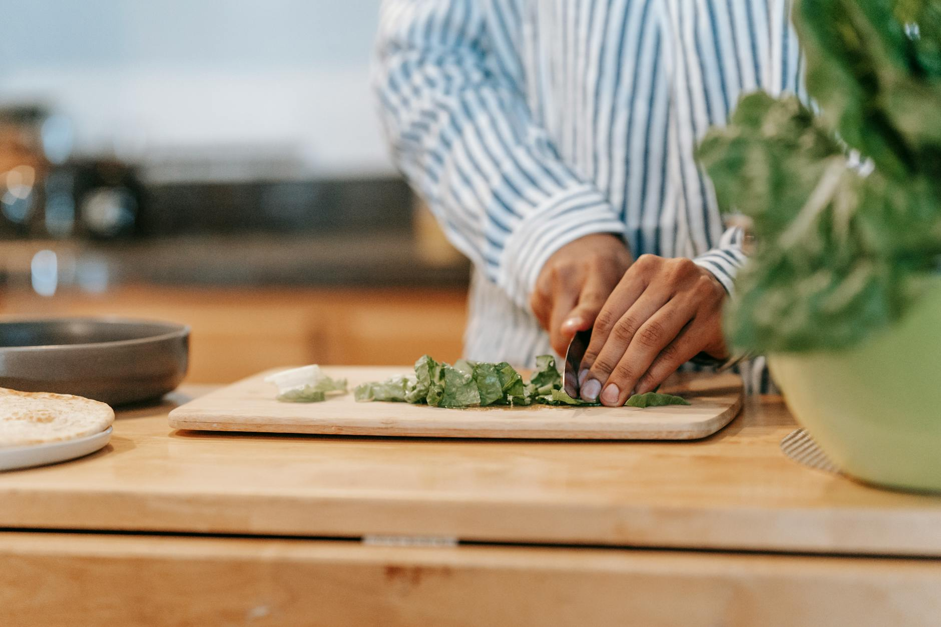 Fresh leafy greens including kale and spinach arranged with nuts and seeds on a wooden cutting board showing micronutrient-rich food sources