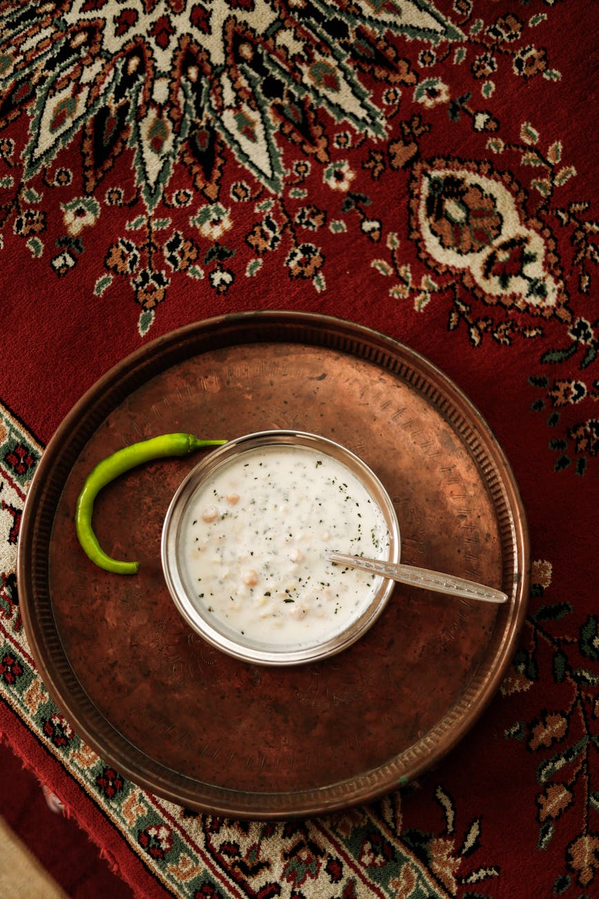 Person shopping for probiotic foods in a grocery store refrigerator section with yogurt, kefir, and fermented foods