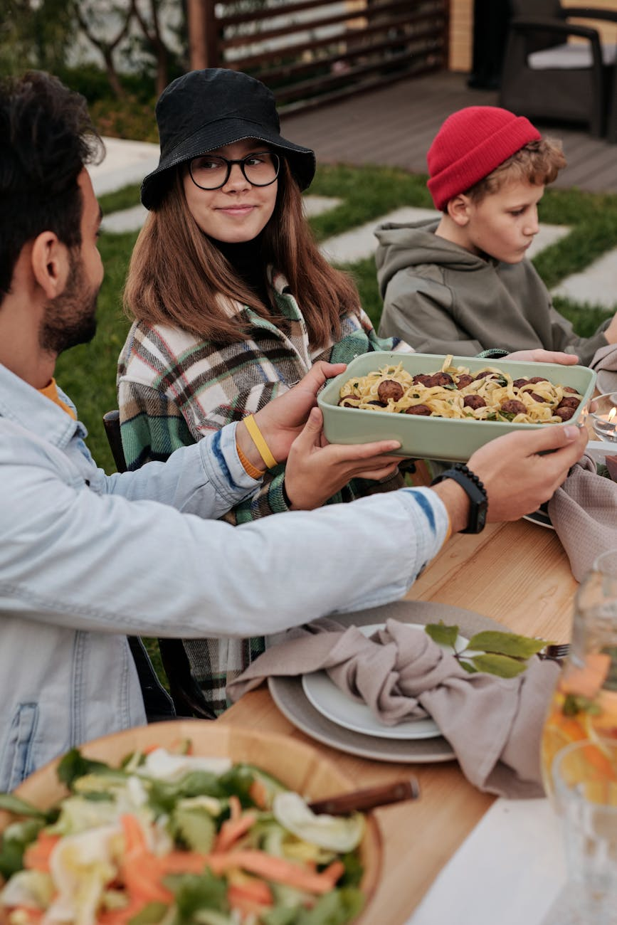 Group of people sharing a meal together outdoors, relaxed and enjoying food without visible stress