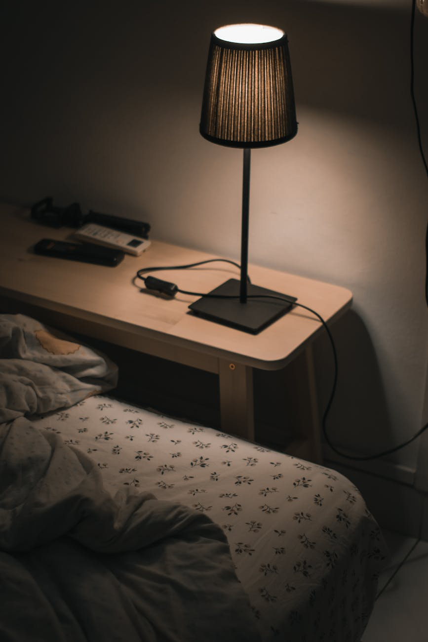 Calm bedroom with warm lighting, a cup of herbal tea, and healthy snacks on the nightstand