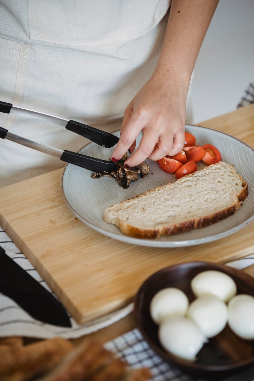 Person preparing a colorful balanced meal with vegetables, lean protein, and whole grains in a bright modern kitchen
