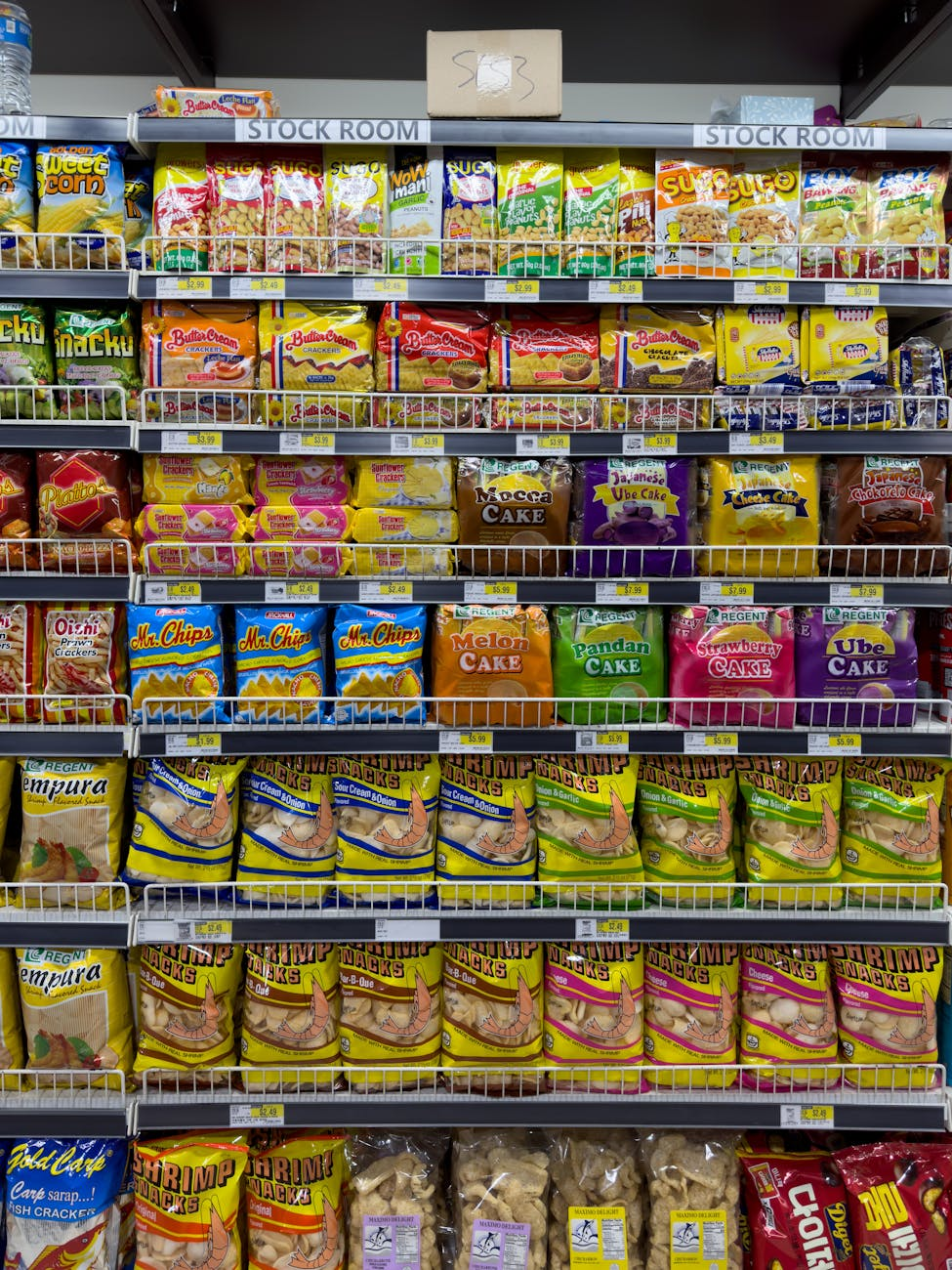 Supermarket shelf stocked with packaged ultra-processed snacks, chips, cereal, and soft drinks illustrating how common they have become