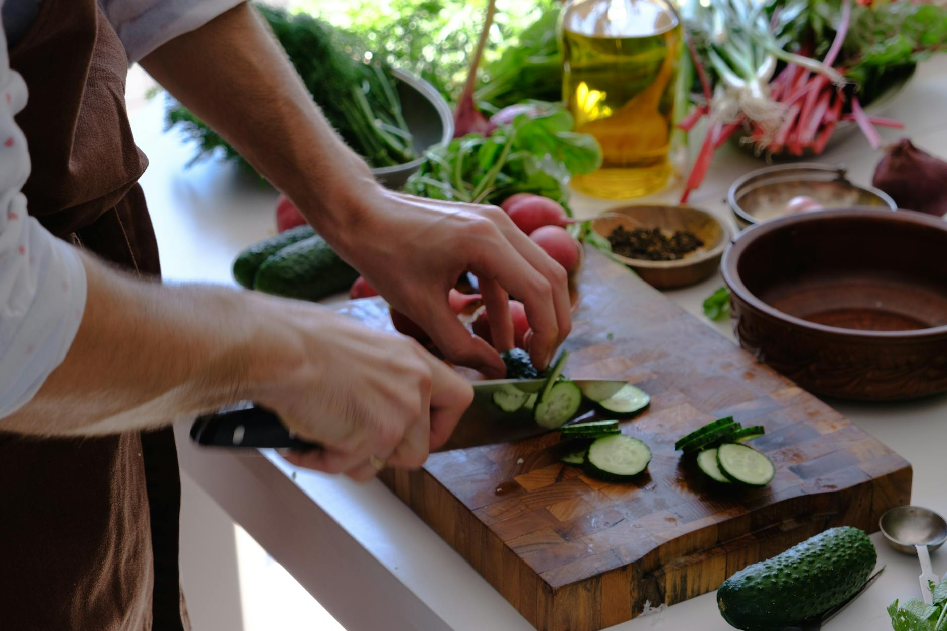 Person preparing a meal from fresh whole-food ingredients on a cutting board in a home kitchen as an alternative to processed foods